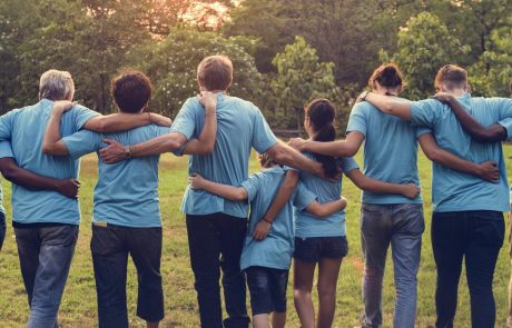 Group of volunteers in a line with arms around each others shoulders